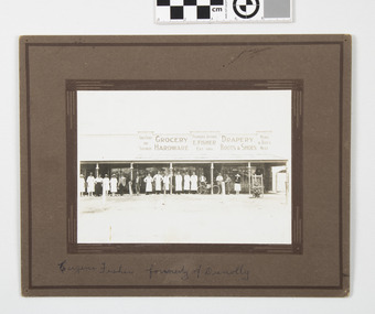 This image depicts 17 staff including Mr and Mrs E Fisher(formerly of Dunnolly) on footpath in front of store