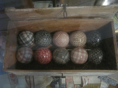Box wooden containing a set of 12 coloured china carpet bowls, Mid 1940s