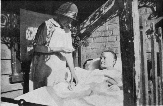 A Sister from the Melbourne District Nursing Society visiting a patient at home