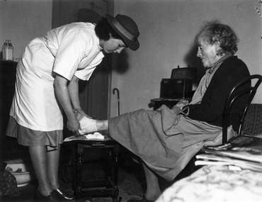 Melbourne District Nursing Society (MDNS) Sister bandaging a lady's ankle