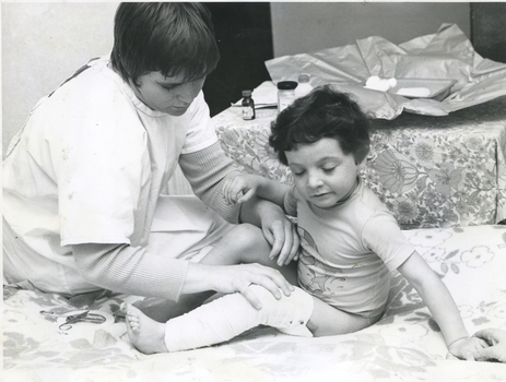 A Royal District Nursing Service Sister attending to a child's wounds