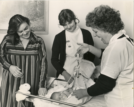 Royal District Nursing Service DIMC Sister J. Wan weighing a baby.