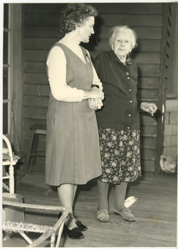 A Royal District Nursing Service (RDNS) Sister taking an elderly lady for a walk