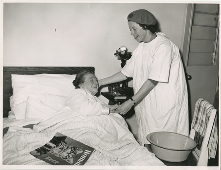 A Melbourne District Nursing Service (MDNS) Sister attending an elderly lady in her home