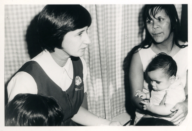 A Royal District Nursing Service (RDNS) Sister visiting a mother and babe in their home