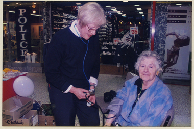 A Royal District Nursing Service (RDNS) Sister carrying out health screening in a Shopping centre