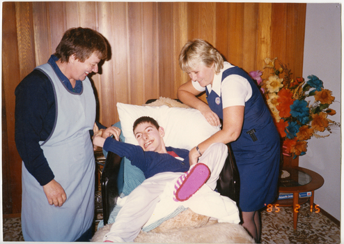 Two Royal District Nursing Service (RDNS) Sisters attending a patient in his home