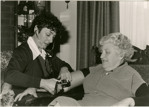 A Royal District Nursing Service (RDNS) Sister checking a lady's blood pressure