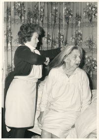 A Royal District Nursing Service (RDNS) Home Health Aide administering care to a lady in her home