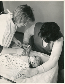 A Royal District Nursing Service (RDNS) Sister dressing a baby's lesions