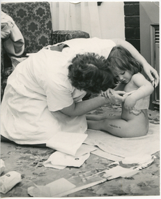 A Royal District Nursing Service (RDNS) Sister attending to a child's wounds