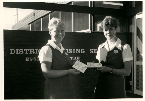 Two Royal District Nursing Service (RDNS) Sisters, each holding an RDNS 1st day Cover envelope