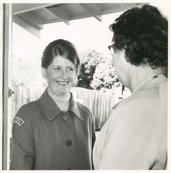 A Royal District Nursing Service (RDNS) Sister being greeted by a patient