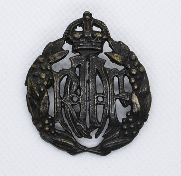Blackened brass badge with crown on top and leaf crest either side of the letters RAAF in centre