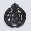Back of blackened brass badge with crown on top and leaf crest either side of the letters RAAF in centre. Single brass fastening loops on left and right.