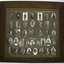Tan coloured wooden glass-fronted frame with handpainted card mount of collage of soliders sepia or black and white photograph portraits with each soldier's name painted underneath each portrait.