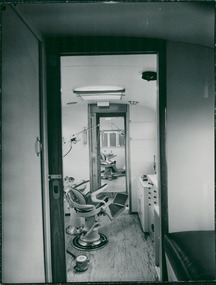 Photograph, This photograph is assumed to be the interior of the truck which is used as a Department of Health program School Dental Service. The picture shows two rooms, each with a dental chair & cabinets with drawers