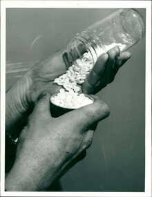 Photograph, The photo shows a pair of hands, one holding and tipping the jar, the other hand holding the jar lid to contain some of the tablets that have been tipped out - Department Of Health - Publicity Photographs circa 1980s
