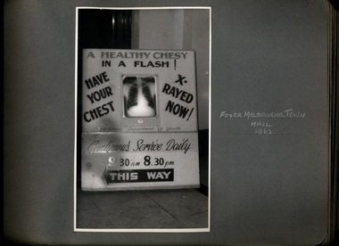 Photograph, "A Healthy Chest in a Flash" "Have your Chest X-rayed Now" promotional billboard displayed in the foyer of the Melbourne Town Hall 1962 - Department of Health - Tuberculosis Branch - Publicity material