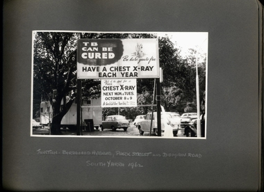 Photograph, "TB Can be Cured - Have a Chest X-Ray Each Year" promotional street signage at the junction of Birdwood Avenue, Park St and Domain Rd South Yarra 1962 - Department of Health - Tuberculosis Branch - Publicity material