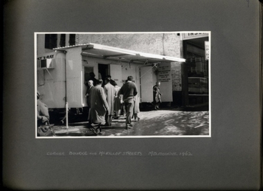 Photograph, Anti Tuberculosis Campaign - People queuing and exiting X-ray caravan on a wet day on the Corner of Bourke & McKillop Streets Melbourne 1962 - Department of Health - Tuberculosis Branch - Chest X-Ray Surveys program