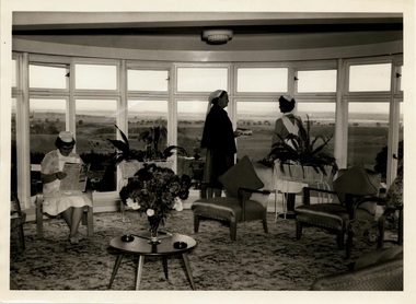 Photograph, A nurse sitting reading whilst two others stand in front of bay windows with a spectacular view in the Caloola Sunbury Nurses in Lounge - 1964