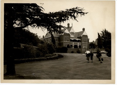 Photograph, Caloola - previously Sunbury Mental Hospital - Photo of a nurse guiding a women, followed by a gentleman with suitcase, all walking towards the main building of Caloola - previously Sunbury Mental Hospital - circa 1964