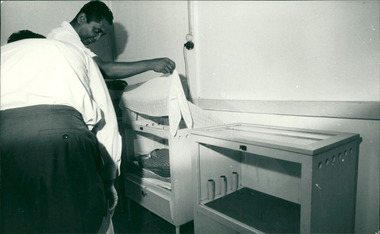 Photograph, Medical staff viewing an occupant of an infant incubator - Dr John A Forbes Fairfield / Gull Force 2/21 Bn AIF / Ziarah Caltex & Rumah Sakit Ambon Hospital - Photo is from Dr John Forbes photo albums - 1971