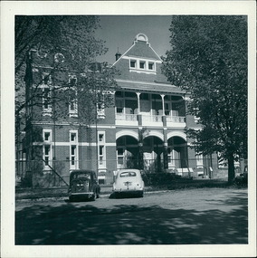 Photograph, 2 cars - An Austin & an early model Holden parked on Windermere St., outside Ballarat Base Hospital 13/02/1959 - Regional & District Hospital Collection - Department of Health & Human Services (DHHS)