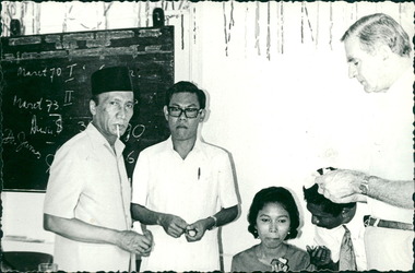 Photograph, Officials and medical staff and Dr Forbes in informal discussions near blackboard - Dr John A Forbes Fairfield / Gull Force 2/21 Bn AIF / Ziarah Caltex & Rumah Sakit Ambon Hospital - Photo is from Dr John Forbes photo albums - 1971