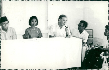 Photograph, Officials and medical staff, and Dr Forbes with pipe, engaged in informal discussions inside the Hospital,  - Dr John A Forbes Fairfield / Gull Force 2/21 Bn AIF / Ziarah Caltex & Rumah Sakit Ambon Hospital - Photo is from Dr John Forbes photo albums - 1971