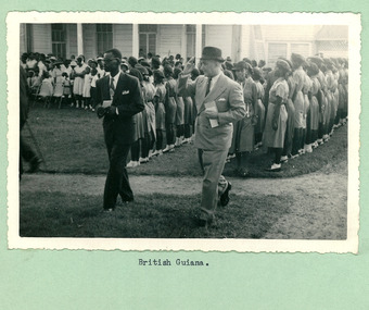 A British government official, and Girl Guides and civilians taking part in a ceremony marking Empire Youth Day in British Guiana South America - Department of Health – National Fitness Office (Sports & Recreation) – Historical Press Release Photo Collection