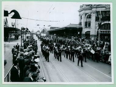 A Brass Band followed by Sea Cadets passing Flinders Street Station on the way to the Melbourne Town Hall on Swanston Street, Melbourne CBD Australia, from the War Memorial - Department of Health – National Fitness Office (Sports & Recreation) – Historical Press Release Photo Collection
