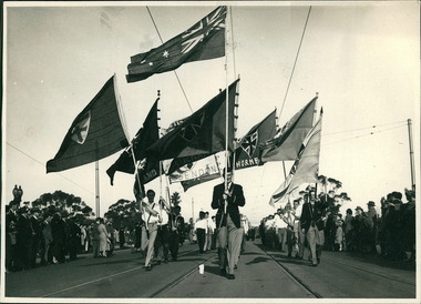 A group of school flag bearers crossing the Princes Bridge marching towards to the Melbourne Town Hall on Swanston Street, Melbourne CBD Australia - 1948, from the War Memorial - Department of Health – National Fitness Office (Sports & Recreation) – Historical Press Release Photo Collection