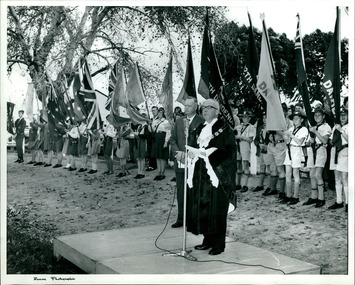 Guides Scouts and School flags behind the mayor who is standing on a salute base at a rally held in the City of Dandenong in 1948, Melbourne, Australia - 1 of 2 photos - Department of Health – National Fitness Office (Sports & Recreation) – Historical Press Release Photo Collection