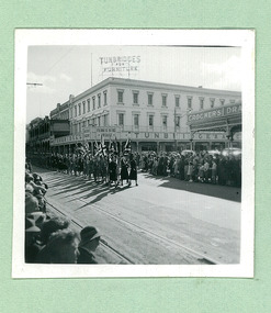 Girl Guides and Brown Owls passing Turnbridges Arcade and Crockers Drapery on Sturt Street - Note: Tram tracks - on Empire Youth day march held in Ballarat in 1958 - Department of Health – National Fitness Office (Sports & Recreation) – Historical Press Release Photo Collection