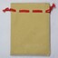 Back of a small faux suede jewellery pouch with a red draw string.