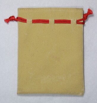 Back of a small faux suede jewellery pouch with a red draw string.