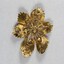 Back of a gold-toned metal brooch with one large central faux pearl surrounded by six smaller faux pearls.