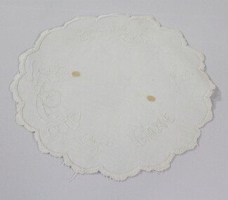 Haeusler Collection Embroidered white doily with the word cake and a floral pattern embroidered on the surface 