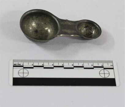 Haeusler Collection Lactogen baby formula measuring spoon with silver toned alloy pictured with 10cm scale