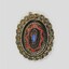 Front of an oval brooch in gold toned metal with red, blue and black inlay.