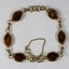 Back surface of a gold toned metal bracelet from the Sarah Coventry Pty. Ltd. jewellery range with small brown oval faux stones