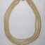Front of a necklace from the Sarah Coventry with a 5 cm black and white scale.