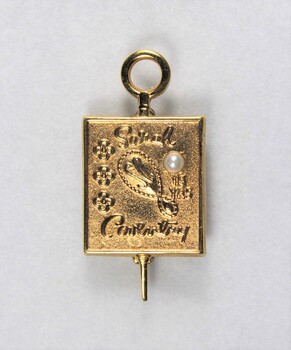 Front of a small gold metal pin for 15 years, with a pearl inlay.