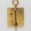 Back of a Sarah Coventry gold metal pin for ten years service, with a pink stone inlay on the proper left side and a clear stone on the proper right side.