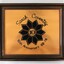 Front of a brown wooden fame on a copper plaque commemorating Sarah Coventry 10th Anniversary from 68-78.