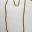 Gold toned metal rope chain from the Sarah Coventry jewellery range, with a small rhombus-shaped attachment at the clasp and a black and white 5 cm scale.