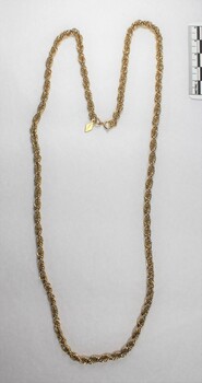 Gold toned metal rope chain from the Sarah Coventry jewellery range, with a small rhombus-shaped attachment at the clasp and a black and white 5 cm scale.