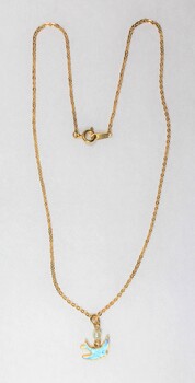 Front of a necklace with a gold toned metal chain and a small blue bird pendant and a small faux pearl. 